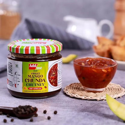 Jar of Adda Sweet Mango Chunda Chutney with a bowl of chutney on a table.